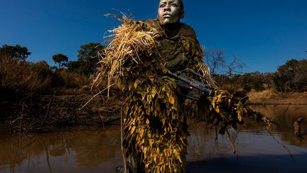 Réserve naturelle de Phundundu, Zimbabwe, juin 2018. Exercice de camouflage et de dissimulation. Petronella Chigumbura (30 ans) est membre d’Akashinga (les braves), une unité anti-braconnage composée exclusivement de femmes.&nbsp;&nbsp; (BRENT STIRTON / GETTY IMAGES)