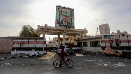 Un homme passe devant un portrait de l'ancien président Hafez al-Assad, le 9 décembre 2024, à Damas (Syrie). (BAKR ALKASEM / AFP)