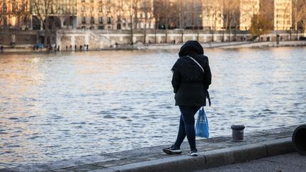 Une femme au bord de la Seine, à Paris, le 16 décembre 2023. (LUC NOBOUT / MAXPPP)