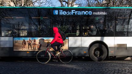 Un cycliste circule près d'un bus, le 10 décembre 2019, à Paris. (RICCARDO MILANI / HANS LUCAS / AFP)