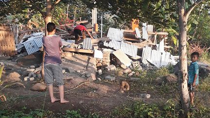 Des indonésiens face à des décombres à la suite d'un séisme de&nbsp;magnitude 6,4 sur l'île de Lombok, le 29 juillet 2018. (NUSA TENGGARA BARAT DISASTER MIT / AFP)