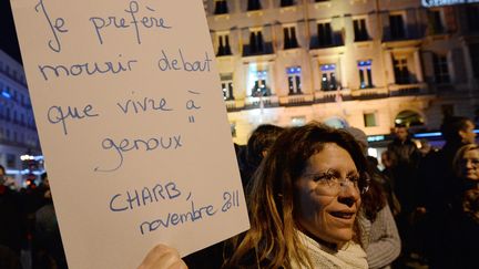 A Marseille, une femme montre, &eacute;crite sur une feuille blanche, cette citation de Charb : "je pr&eacute;f&egrave;re mourir debout que vivre &agrave; genoux". Charb fait partie des quatre dessinateurs tu&eacute;s par les assaillants. (BORIS HORVAT / AFP)