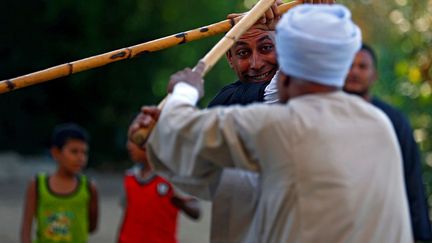 au son d’instruments traditionnels à vent et à cordes et de percussions. Quand la cadence s’accélère, les adversaires effectuent leurs mouvements plus rapidement. Mais à l’inverse, quand la musique ralentit, elle permet de réguler l’agressivité. Si les combattants perdent le contrôle et deviennent trop violents, le public stoppe immédiatement l’affrontement. (Mohamed Abd El Ghany / Reuters)