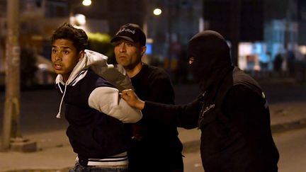 Les forces de sécurité tunisiennes arrêtent un manifestant à Tunis, mercredi 10 janvier 2018. (FETHI BELAID / AFP)