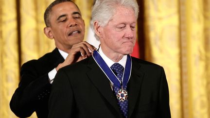 Le pr&eacute;sident am&eacute;ricain Barack Obama d&eacute;core de la m&eacute;daille de la Libert&eacute; l'ancien pr&eacute;sident Bill Clinton &agrave; Washington (Etats-Unis), le 20 novembre 2013. (WIN MCNAMEE / GETTY IMAGES)