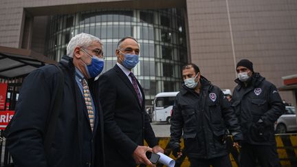 Le pilote Noyan Pasin (à droite), accusé d'avoir aidé Carlos Ghosn dans sa fuite du Japon, se rend au tribunal d'Istanbul accompagné de son avocat, le 24 février 2021. (OZAN KOSE / AFP)
