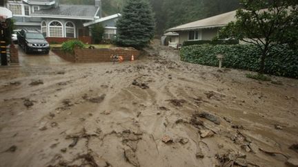 Des torrents de boue s'écoulent entre les maisons suite à des pluies diluviennes qui balayent la Californie (21/01/2010) (AFP/GETTY IMAGES NORTH AMERICA/DAVID MCNEW)