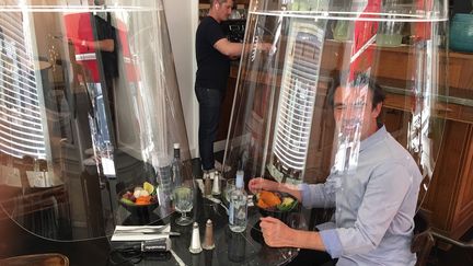 Christophe Gernigon présente son Plex'eat dans un restaurant parisien. Une cloche en plexiglas qui permet de protéger les clients contre le coronavirus. (BENJAMIN MATHIEU / FRANCEINFO / RADIO FRANCE)