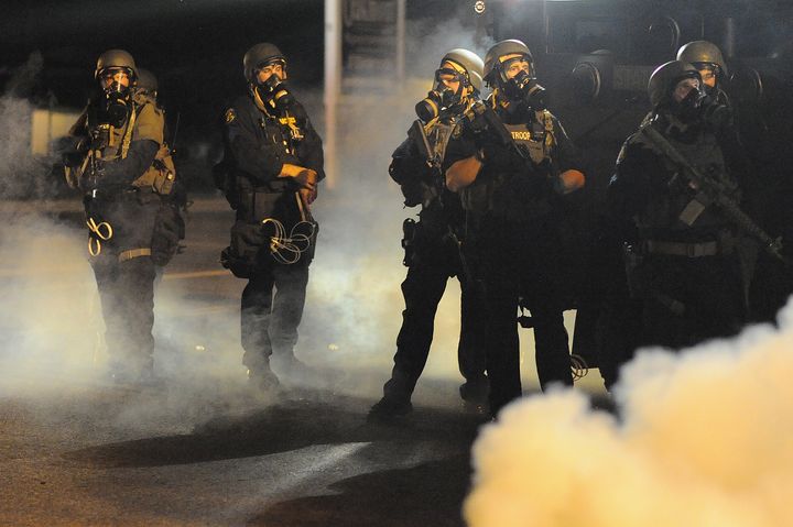 Les forces de l'ordre montent la garde au milieu de la fum&eacute;e de gaz lacrymog&egrave;ne, &agrave; Ferguson, le 18 ao&ucirc;t 2014. (MICHAEL B THOMAS / AFP)