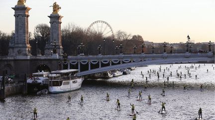 Des centaines de personnes descendent la Seine en "paddle" &agrave; l'occasion du salon Nautique &agrave; Paris, le 6 d&eacute;cembre 2014. (THOMAS SAMSON / AFP)