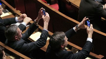 Des d&eacute;put&eacute;s prennent des photos de l'h&eacute;micycle &agrave; l'Assembl&eacute;e nationale lors de la derni&egrave;re session de questions au gouvernement avant la suspension de la saison l&eacute;gislative, Paris, le 6 mars 2012. (JACQUES DEMARTHON / AFP)