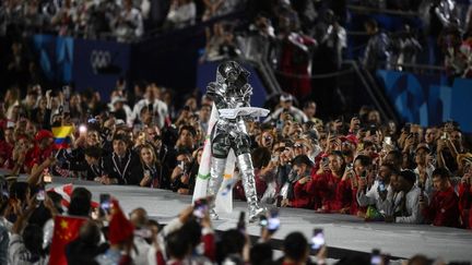 Le drapeau olympique arrivant au Trocadéro où se tient la partie finale de la cérémonie d'ouverture. (OLI SCARFF / AFP)