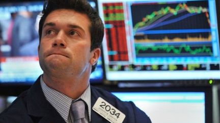 Un boursier contemple, perplexe, l'évolution des indices à Wall Street (archive du 8-8-2011) (AFP - Stan HONDA)