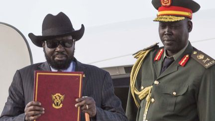 Le président du Soudan du Sud, Salva Kirr, de retour à Juba, avec une copie de l'accord de cessez-le-feu et de partage du pouvoir signé enre le pouvoir et les rebelles de Riek Machar le 6 août 2018. (AKUOT CHOL / AFP)