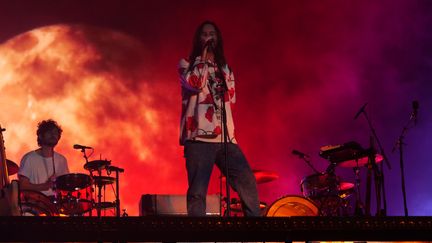 Kevin Parker apparaît, jean, T-shirt et chemise à fleurs sur le dos. Les salutations au public passées, une lumière rougêatre s'abat sur la prairie de la grande scène. Soudain, la voix frappante de justesse de ce magicien du rock psychédélique&nbsp;nous possède.&nbsp;À ses côtés ses musiciens dont le batteur français Julien&nbsp;Barbagallo,&nbsp;"le meilleur batteur du monde"&nbsp;selon l’australien, visiblement à l'aise en français. Le voyage peut officiellement commencer. (NISRINE MANAI)