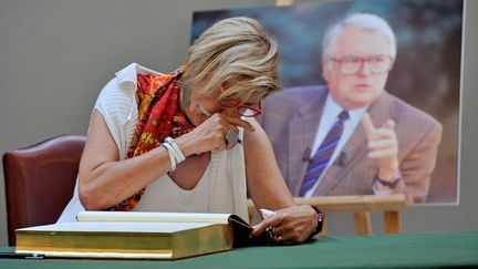 Une femme en pleurs, signant un livre de condol&eacute;ances, le 7 juin 2013, apr&egrave;s l'annonce de la mort de Pierre Mauroy, &agrave; l'h&ocirc;tel de ville de Lille (Nord). (PHILIPPE HUGUEN / AFP)