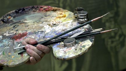 Une palette de peinture et des pinceaux. (DAVID HANCOCK / AFP)