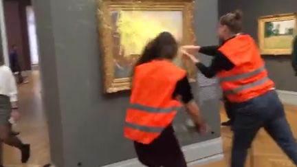 Des militants écologistes du groupe de désobéissance&nbsp;civile Letzte Generation lancent de la purée de pommes de terre, sur un tableau de Claude Monet dans un musée de Postdam, en Allemagne,&nbsp;le&nbsp;23 octobre 2022. (TWITTER LETZTE GENERATION)