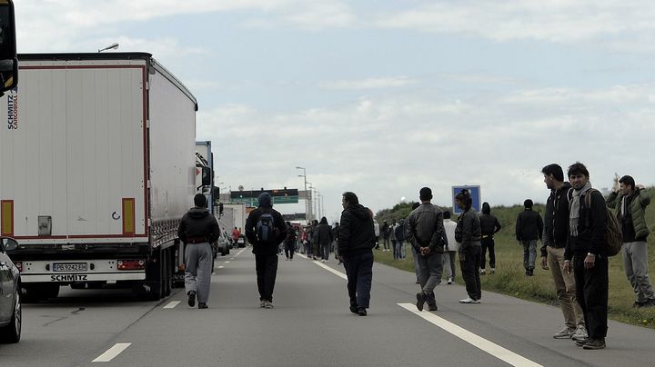 Des migrants profitent d'un embouteillage aux abords du port de Calais pour tenter de monter &agrave; bord de camions en partance pour l'Angleterre, le 20 mai 2015. (SARAH ALCALAY / SIPA)