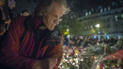 Un homme se recueille, place de la République, à Paris, le 15 novembre 2015. (OLIVIER DONNARS / NURPHOTO / AFP)