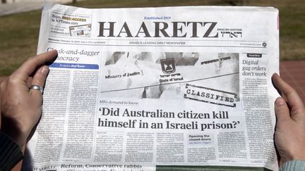 Une femme lit le quotidien isra&eacute;lien "Haaretz", qui &eacute;voque le suicide d'un prisonnier australien, pr&eacute;sent&eacute; comme un agent du Mossad, dans des circonstances &eacute;tranges, le 13 f&eacute;vrier 2013, &agrave; J&eacute;rusalem. (AHMAD GHARABLI / AFP)