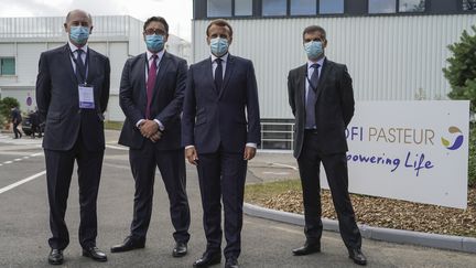 Serge Weinberg, directeur général de Sanofi, Emmanuel Macron et Olivier Bogillot, président de Sanofi France, posent pour une photo de groupe à l'usine Sanofi Pasteur de Marcy-l'Etoile, près de Lyon, mardi 16 juin 2020. (LAURENT CIPRIANI / POOL / AP POOL )