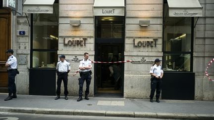 Des policiers surveillant l'entrée de la bijouterie braquée le 1er juin 2010 à Lyon (AFP - JEAN-PHILIPPE KSIAZEK)