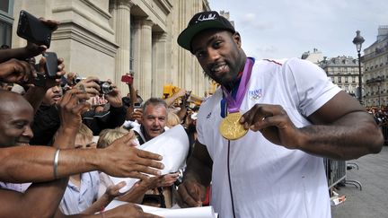 Sur le parvis de la gare du Nord, le "colosse" Teddy Riner, m&eacute;daille d'or autour du cou, fait partie des ath&egrave;tes les plus sollicit&eacute;s par la foule. (MEHDI FEDOUACH / AFP)