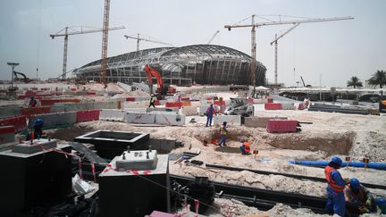 Des ouvriers sur le chantier du stade&nbsp;Al-Wakrah, à Doha (Qatar), en construction pour la Coupe du monde de football organisée en 2022 dans le pays. (RAMIL SITDIKOV / SPUTNIK / AFP)