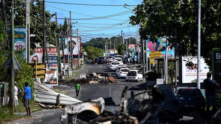 Un piéton traverse un barrage filtrant à Mare Gaillard, près de Pointe-a-Pitre&nbsp;en Guadeloupe, le 22 novembre 2021. (CHRISTOPHE ARCHAMBAULT / AFP)