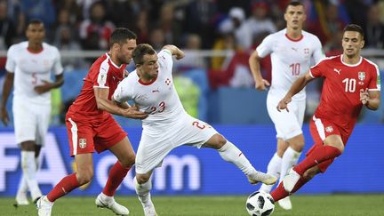 Le Suisse Xherdan Shaqiri accroché par le Serbe Dusko Tosic (OZAN KOSE / AFP)