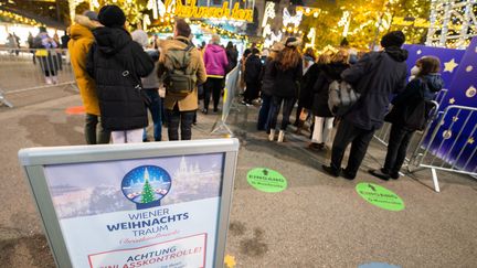 Un panneau prévient les visiteurs du marché de Noël situé en face de la mairie, à Vienne (Autriche), que leur pass sanitaire sera contrôlé, le 12 novembre 2021. (GEORG HOCHMUTH / APA)