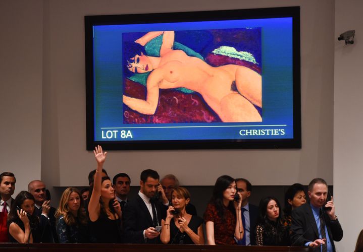 Des acheteurs devant "Nu couché" d'Amedeo Modigliani, lors d'une vente aux enchères à New York (Etats-Unis), le 9 novembre 2015. (TIMOTHY A. CLARY / AFP)