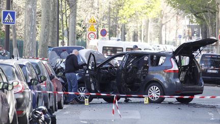 Des enqu&ecirc;teurs inspectent la voiture utilis&eacute;e par des braqueurs, jeudi 18 avril, pour bloquer et puis attaquer des convoyeurs de fonds, au&nbsp;57 boulevard Pereire dans le 17e arrondissement de Paris. ( MAXPPP)