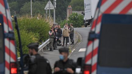 Des gendarmes barrent une route à quelques mètres du lieu où se déroule une fête interdite à Redon (Ille-et-Vilaine), le 19 juin 2021. (LOIC VENANCE / AFP)