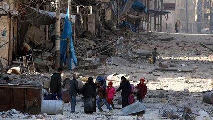 Des civils marchent dans les décombres d'un quartier de l'est d'Alep (Syrie), le 28 novembre 2016. (ABDALRHMAN ISMAIL / REUTERS)