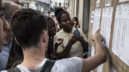 Des élèves découvrent les résultats du baccalauréat au lycée Ampère, à Lyon (Rhône), le 7 juillet 2015. (JEAN-PHILIPPE KSIAZEK / AFP)