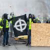 Des manifestants vêtus d'un "gilet jaune" dressent un drapeau avec une croix celtique, un symbole d'extrême droite, à Paris, le 1er décembre 2018. (LUKE DRAY/COVER IMAGES/SIPA)