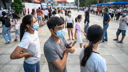 Des personnes patientent pour réaliser un test de dépistage du Covid-19, le 30 novembre 2022 à Guangzhou (Chine). (STRINGER / ANADOLU AGENCY / AFP)