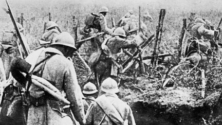 Photo non datée d'une escouade de soldats français franchissant les lignes de fils de fer barbelés pour lancer une attaque à Verdun.
 (OFF / AFP)