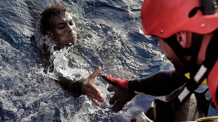 Sauvetage d'un migrant en Méditerranée à plusieurs dizaines de kilomètres au nord des côtes libyennes, le 3 octobre 2016. (Photo AFP/Aris Messinis)