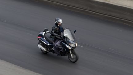 Un homme en scooter, à Paris, le 9 février 2015.&nbsp; (KENZO TRIBOUILLARD / AFP)