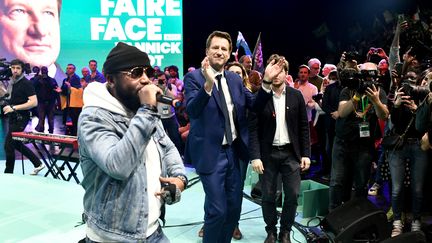 Le candidat écologiste Yannick Jadot danse aux côtés du groupe de rap français Ärsenik venu le soutenir à l'occasion d'un rassemblement au Zénith de Paris le 27 mars 2022. (STEPHANE DE SAKUTIN / AFP)