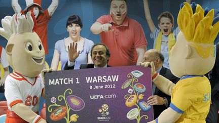 Michel Platini, pr&eacute;sident de l'UEFA,&nbsp;entre Slavek et Slavko, les mascottes de l'Euro 2012, le 31 mars 2011 &agrave; Varsovie (Pologne).&nbsp; (JANEK SKARZYNSKI / AFP)