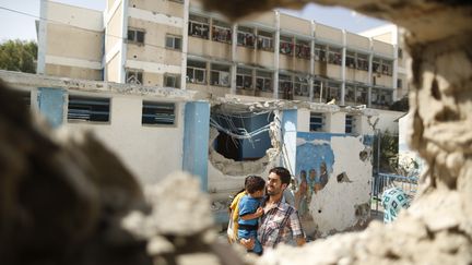  (Un Palestinien et un enfant devant l’école des Nations unies bombardée mercredi à Gaza. © REUTERS / Suhaib Salem)