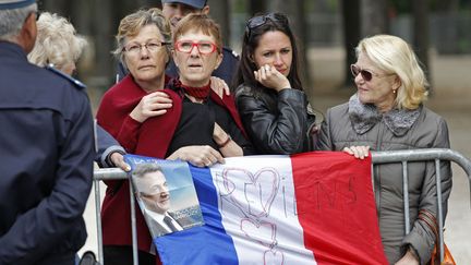 Devant le palais de l'Elys&eacute;e, des partisans de Nicolas Sarkozy sont venus lui rendre hommage. (STEPHANE MAHE / REUTERS)