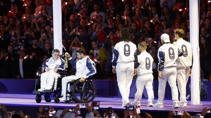 Six athlètes français éteignent la flamme lors de la cérémonie de clôture des Jeux paralympiques, le 8 septembre 2024, au Stade de France. (GEOFFROY VAN DER HASSELT / AFP)