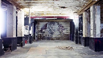 Vhils,  étoile montante du street-art, est connu pour sa technique innovante : il réalise souvent ses oeuvres au burin et à l'explosif, créant des reliefs et découvrant d'anciennes couches. Cette fois, c'est muni d'un marteau-piqueur qu'il s'est attaqué au mur de l'ancienne piste de danse du club. Ce jeune Portugais n'avait jamais mis les pieds aux Bains Douches, mais il connaissait le lieu de réputation.
 (Photo Stéphane Bisseuil - Courtesy Magda Danysz)