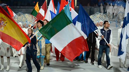 Les porte-drapeaux (&agrave; gauche, le Fran&ccedil;ais Martin Fourcade) ont d'abord d&eacute;fil&eacute;. Suivis ensuite par tous les athl&egrave;tes encore pr&eacute;sents &agrave; Sotchi&nbsp;qui ont d&eacute;ferl&eacute; dans le stade Fisht, en courant, sautant et en dansant. (PETER PARKS / AFP)