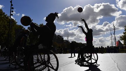 Des joueurs de basket fauteuil prennent part à une initiation lors de la journée paralympique, organisée Place de la Bastille à Paris, le 8 octobre 2022 (JULIEN DE ROSA / AFP)